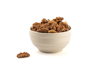 Peeled walnuts in a ceramic bowl and on a white background.