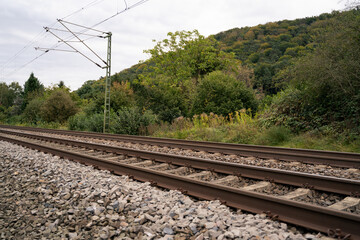 Two railway tracks in a rural environment with a cloudy sky