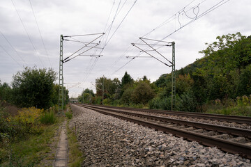 Two railway tracks in a rural environment on an autumn day with cloudy sky