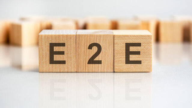 e2e - letters on wooden cubes. business as usual concept image. front view