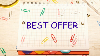 Best Offer text on a notebook in a cage with scattered paper clips on a notebook and a table