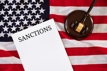 Sanctions list and judge's gavel on background of USA flag.