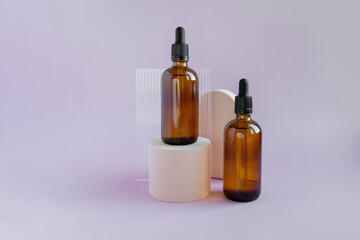 set Cosmetic bottle made of dark amber glass without labels on a bright lilac background with geometric shapes. With place for your design. Minimalist brand packaging mockup.