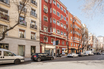Facades of residential buildings painted red in an avenue in the center of the city of Madrid