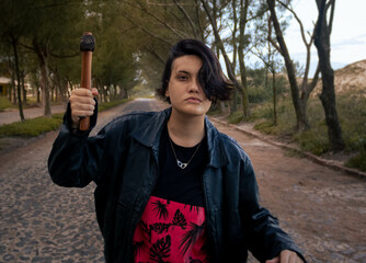 Young male gender fluid female on a cobblestone street with a tunnel of trees in the background...