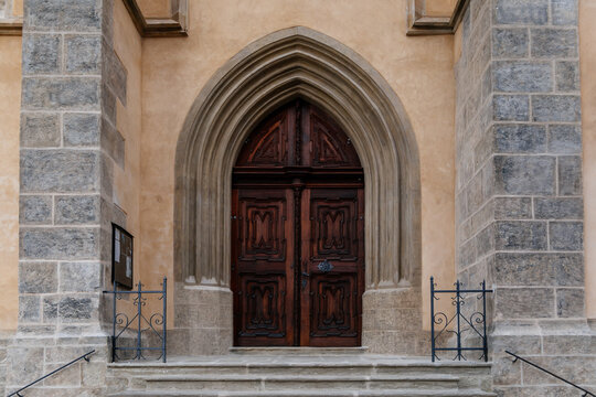 Kutna Hora, Central Bohemian, Czech Republic, 5 March 2022: Gothic stone Church of St. James or Kostel sv. Jakuba with wooden carved arched doors, medieval architecture at old town