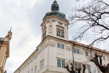 Fototapeta na wymiar Kutna Hora, Central Bohemia, Czech Republic, 5 March 2022: Baroque Former Jesuit College with tower and dome, medieval architecture gothic and renaissance at old town, vineyards on a slope