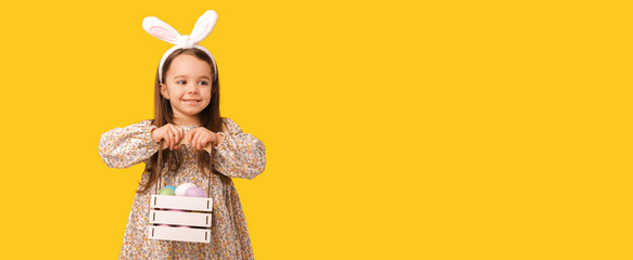 Close up banner photo of a cheerful girl holding a basket with easter eggs.