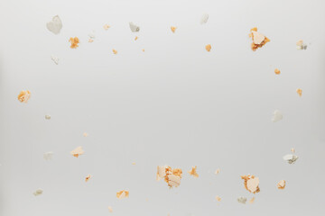 Pattern with white, yellow, gold macaron cookies lids, covers, parts and bites laying chaotically on the white table. Light beige or gray background. Broken cut, pieces with empty copy space area