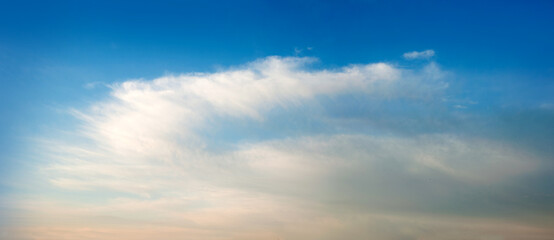 Naklejka na ściany i meble white-orange fluffy clouds in the blue sky, background