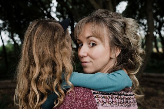 portrait of mother looking back whilst holding daughter