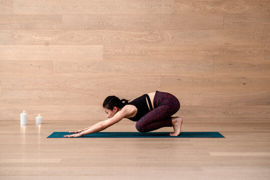 Full length of a young woman sitting in child's pose on a yoga mat