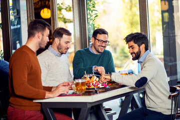 Obraz na płótnie Canvas Group of friends enjoying in beer pub