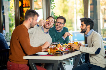 Fototapeta na wymiar Group of friends enjoying in beer pub