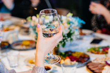 hands with glasses above the festive table