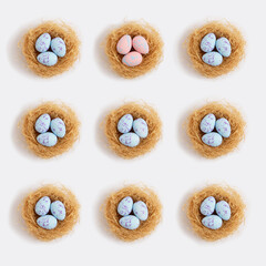 Pattern pastel easter eggs in nests on a white background. Minimal creative concept of Easter.