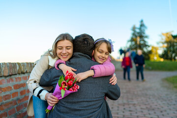 A family hug from a family of three. Father, mother and daughter