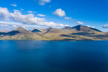 Fototapeta na wymiar Scottish mountains with sea water on a sunny day, aerial shot, Isle of Mull