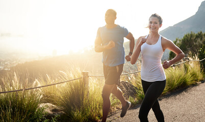 Some call it running we call it life. Shot of a sporty couple out running on a mountain road.