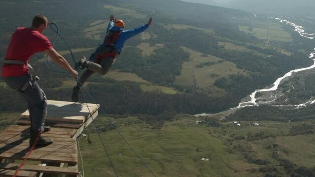 rope jumping, a man jumps from a mountain, a safe fall from a chip