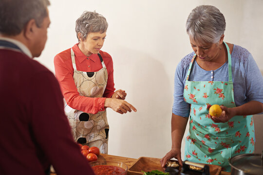 Put on your apron and whip up something incredible. Shot of a group of seniors cooking in the kitchen.