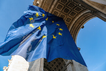 Paris, France: European Union flag flying in the wind under the Arc de Triomphe in March 2022 for a special EU summit on Ukrainian crisis - obrazy, fototapety, plakaty