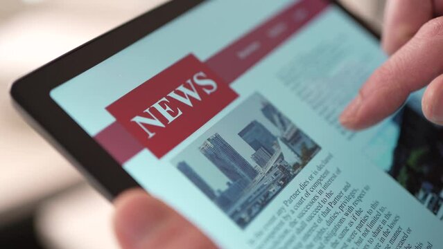 Reading the News Online on a Touch Screen Tablet Closeup