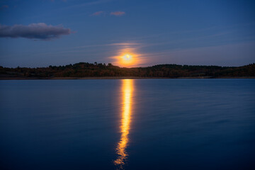 Fototapeta na wymiar Full moon reflection on a lake at night in Sabugal Dam, Portugal
