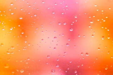 Rain drops on pink and orange gradient background