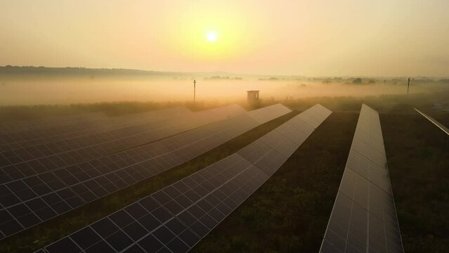Aerial view of large sustainable electrical power plant with rows of solar photovoltaic panels for producing clean electric energy in evening. Concept of renewable electricity with zero emission