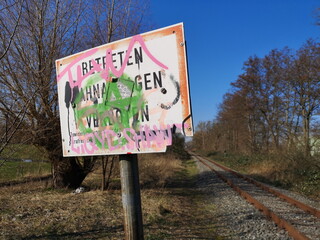 Beschmiertes Schild Bahnanlage Schienen betreten verboten