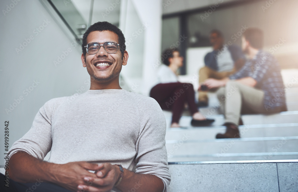 Poster weve taken some exciting steps as a company. portrait of a young designer sitting on a staircase wit