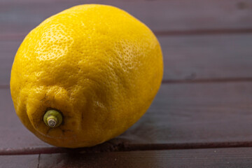 Close up view of yellow lemon fruit isolated on wooden background.