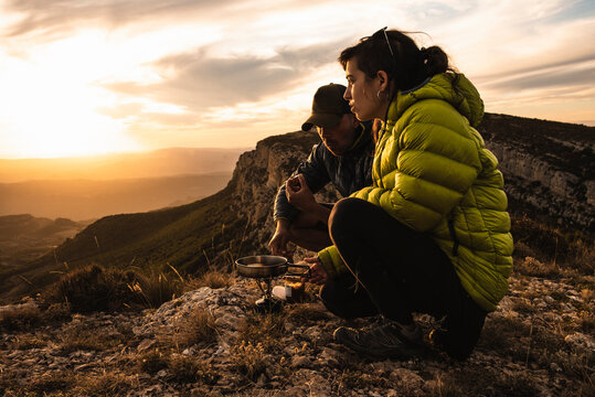 Young couple cooking during a camping trip in the mountains.