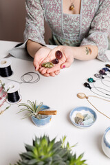 Woman hands making handmade gemstone jewellery, home workshop. Women artisan creates jewellery. Art, hobby, handcraft concept