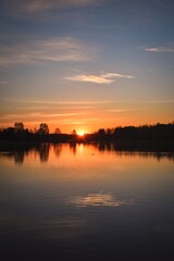 Fototapeta premium Wonderful morning landscape in Poland. The sun over the lake in a colorful sky.