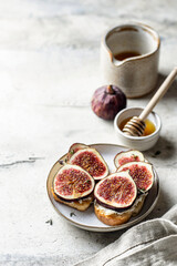 Sandwich with figs, cheese, thyme and honey on textured background