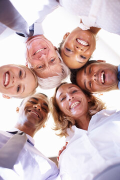 Working Towards Same Goal. Low Angle View Of Multi Racial Business Team In Huddle At Office.