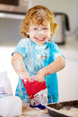 The future of the culinary arts. A little boy covered in dough and flour.