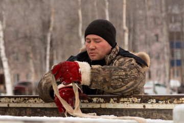 Portrait of a fitter in a winter jacket with a tape rag sling