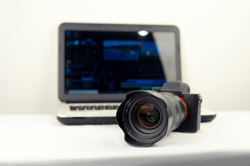Digital photography workstation. Modern DSLR (mirrorless) digital camera,laptop and screen.