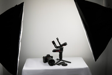 photo camera on a steadicam on a table with a white background - with two illuminations