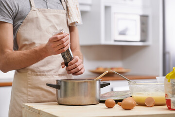 Delicious meal in the making. Cropped shot of a young man cooking in the kitchen.
