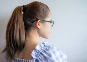 Young woman with ponytail hairstyle from side view. Women commonly wear their hair in ponytails in informal and office settings or when exercising. - obrazy, fototapety, plakaty