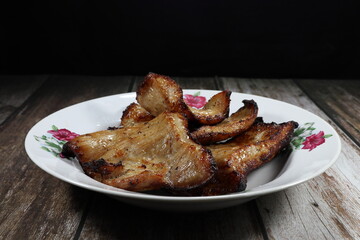 Pile of grilled pork neck serving on the plate. Famous menu in Asian restaurant. 