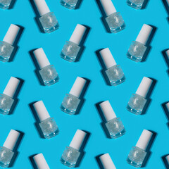 transparent glass bottles of nail polish on blue background. Hard shadows. Kids cosmetic concept