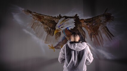 Artist designer draws an eagle on the wall. Craftsman decorator paints a picture with acrylic oil...