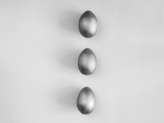 Bw shot of three egg on the grey background. Design, visual art, minimalism, monochrome, black and white photo. Flat lay top view, copy space. Happy Easter concept