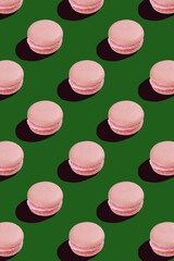 Fototapeta premium pattern with pink macaroons on green background 