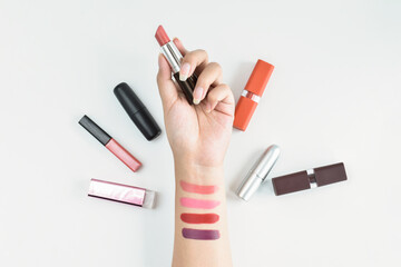 Woman holding the beautiful lipstick and apply on her hand with beauty and cosmetic products on white background